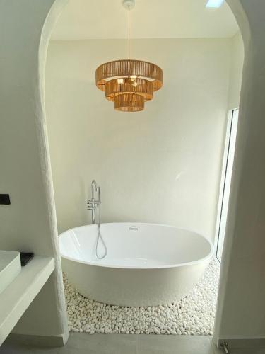 a white bath tub in a bathroom with a chandelier at Huang Su Villa 7 皇宿7号泳池别墅 in Pattaya Central