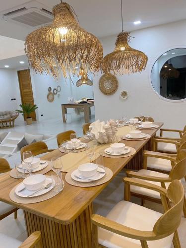 a dining room with a large wooden table and chandeliers at Huang Su Villa 7 皇宿7号泳池别墅 in Pattaya Central
