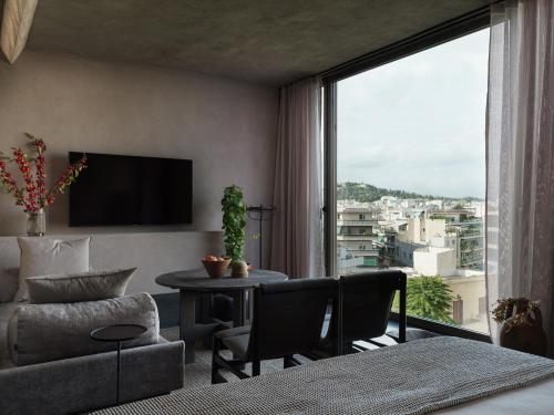 a living room with a couch and a large window at Monastik Living in Athina in Athens