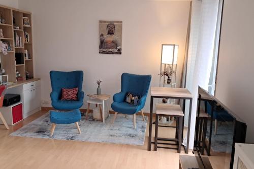 un salon avec deux chaises bleues et une table dans l'établissement Charming T1 with balcony in Hyères, à Hyères