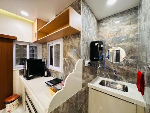 a small kitchen with a sink and a mirror at Shrilok Kutir 1BHK Penthouse in Ujjain
