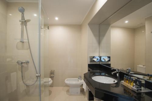 a bathroom with a shower and a sink and a toilet at Vila Gale Ampalius in Vilamoura