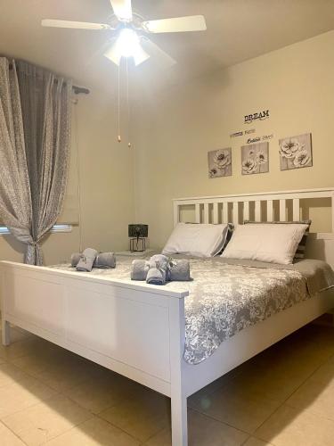 a bedroom with a white bed and a ceiling fan at Sea View Penthouse in Larnaca
