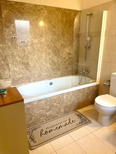 a bathroom with a bath tub and a toilet at Sea View Penthouse in Larnaca