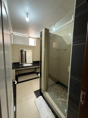 a bathroom with a shower with a sink and a mirror at CapePod City Centre in Cape Town