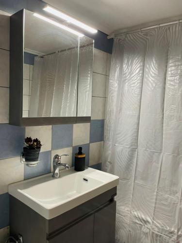 a bathroom with a sink and a shower curtain at Athina in Nea Peramos