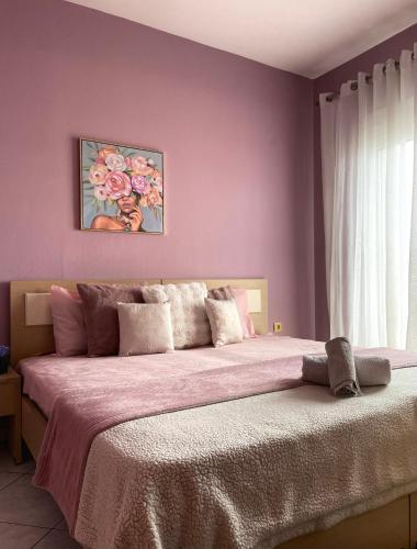 a bedroom with a large bed with purple walls at Athina in Nea Peramos