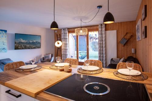 a kitchen and dining room with a table and chairs at Snowbell Gardens by Villars Luxury in Ollon