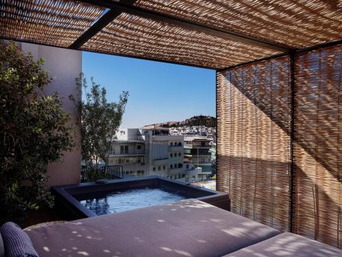a balcony with a hot tub and a view of a city at Monastik Living in Athina in Athens