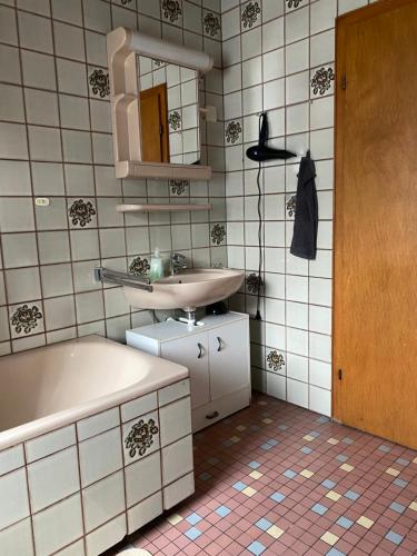 a bathroom with a sink and a tub and a mirror at TOP Apartment! 13km Saarbrücken! große Terrasse! 4 Zimmer! 1-6 Pers, Saarbruecken in Altenwald