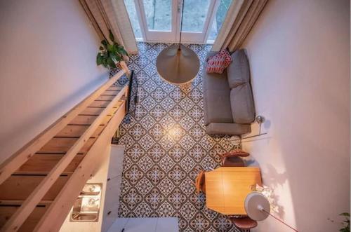 an overhead view of a living room with a couch and stairs at Group accommodation Huize Blokland on nature farm - 14p in Hem