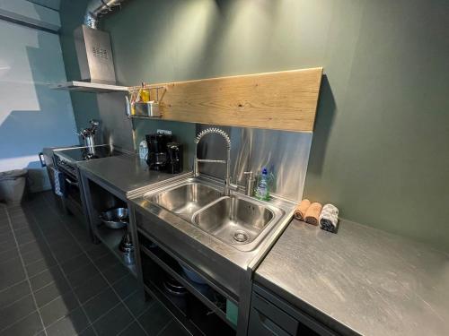 a kitchen with a sink and a counter top at Group accommodation Huize Blokland on nature farm - 14p in Hem
