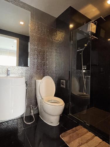 a bathroom with a toilet and a shower at Upscale Apartment With Train Access Bts Thonglor in Bangkok