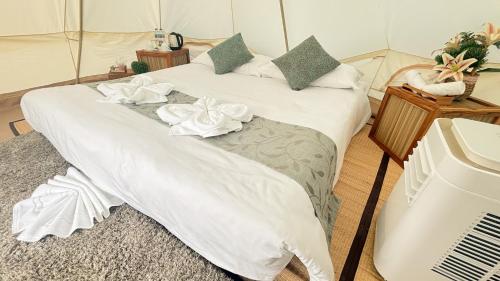 a bed with white sheets and flowers on it at Thailand Mountain Phuket in Patong Beach