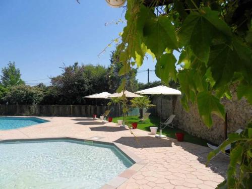 - une piscine avec des parasols et des chaises à côté dans l'établissement Camping 3 étoiles - Piscine - eecbgf, à Urt