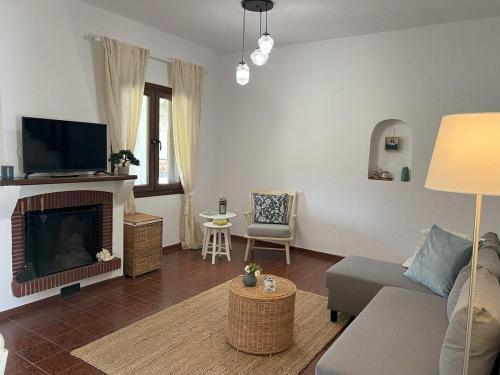 a living room with a couch and a fireplace at DoorMat #20 Beach house Mikiverna in Kalyves Poligirou