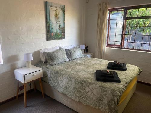 a bedroom with a bed with two bags on it at Nudist Naturist FKK Port Nature Sandy Bay in Cape Town
