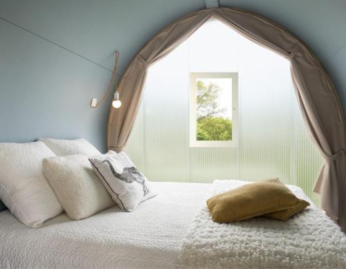 - une chambre avec un lit doté d'un grand cadre dans l'établissement Camping l'Hermitage, à Guéméné-Penfao