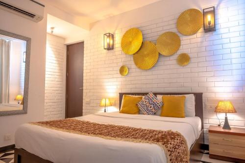 a bedroom with a bed with yellow paper umbrellas on the wall at Magnolia by Da Alohas El Arbol at Candolim in Nerul