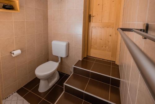a bathroom with a toilet and a wooden door at Chill House in Orfű
