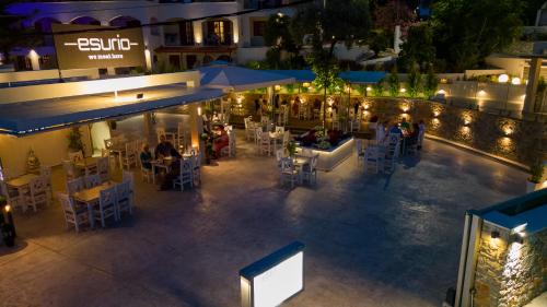 an outdoor restaurant with tables and chairs at night at Hotel Marina in Kolios