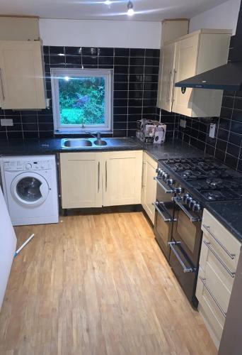 una cocina con fregadero y estufa horno superior en Lovely Milton Keynes Double Room, en Milton Keynes