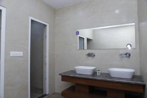 a bathroom with two sinks and a mirror at The Blessing Palace in Muzaffarpur