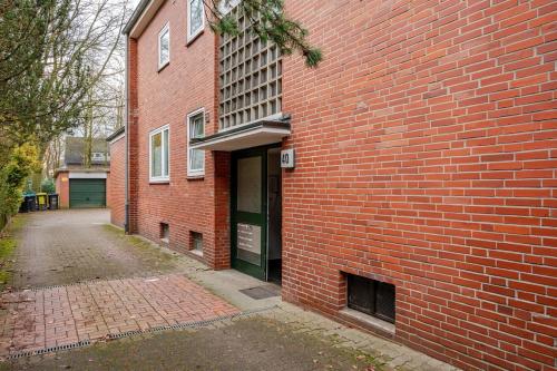 a red brick building with a green door on it at Sleep two Fly in Hamburg