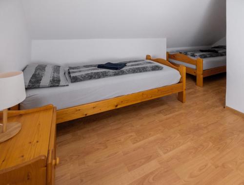 two twin beds in a room with wooden floors at Chill House in Orfű