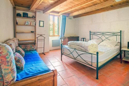 a bedroom with a bed and a couch at Charmante maison au bord de la rivière in Saint-Maurice-Navacelles