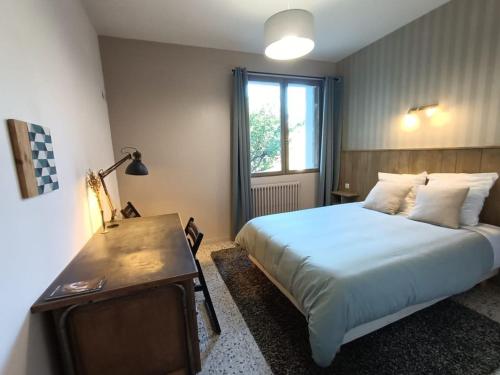 une chambre avec un lit, un bureau et une fenêtre dans l'établissement Les Bois de Malaguet - gite d'étape et de séjour, à Monlet