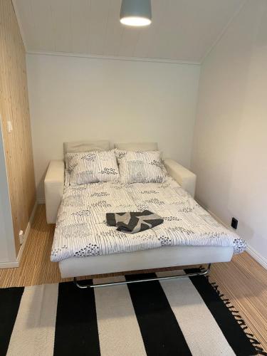 a bedroom with a bed with a black and white comforter at Stylish home in Tikkakoski in Tikkakoski