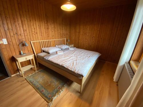 a bedroom with a bed in a wooden room at Japaner Haus in Weitenbach