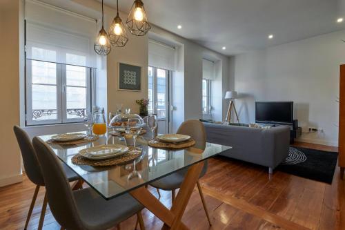 a dining room and living room with a table and chairs at Travessa Houses in Lisbon