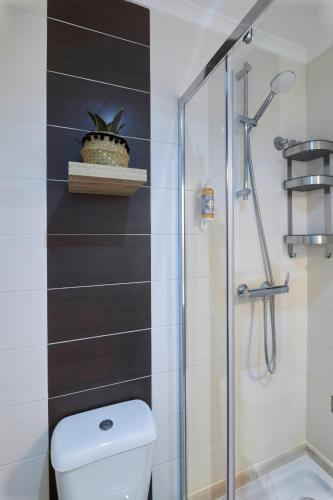 a bathroom with a toilet and a glass shower at Travessa Houses in Lisbon