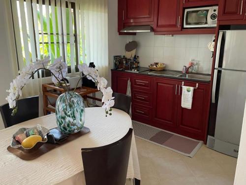 a kitchen with red cabinets and a table with a vase on it at Thailand Dream Village E09 in Klaeng