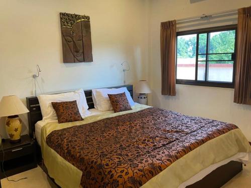 a bedroom with a bed and a window at Thailand Dream Village E09 in Klaeng