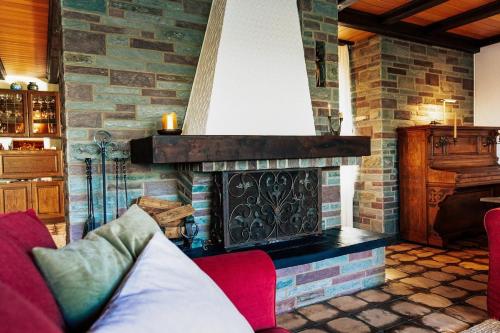 a living room with a fireplace and a red couch at Exklusive Landvilla mit Pool, Sauna und Garten in Schwalmtal
