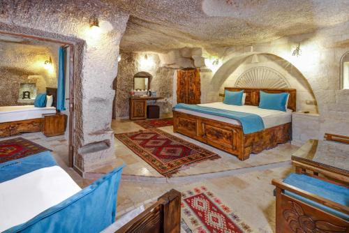 Un dormitorio con una cama en una habitación de piedra. en Angel Cappadocia Cave Hotel, en Göreme