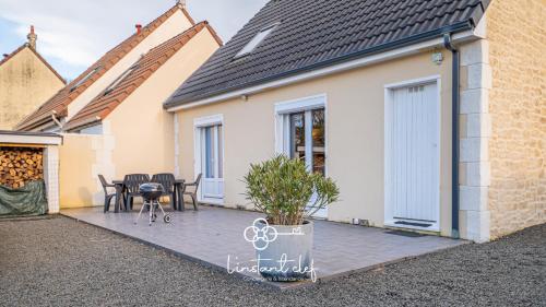 une maison avec un patio avec une table et des chaises dans l'établissement Cocon Familial & Terrasse - Pôle Santé Sud - 10mn Circuit des 24H - L'Instant Clef, au Mans