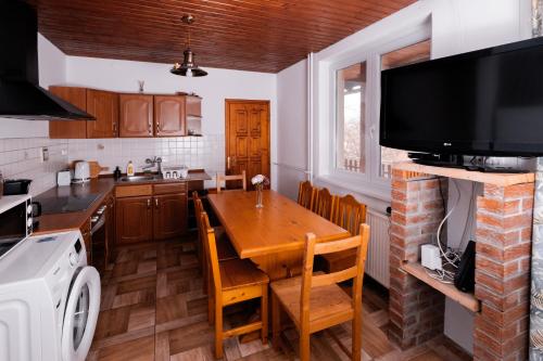 a kitchen with a wooden table and a television at Chill House in Orfű