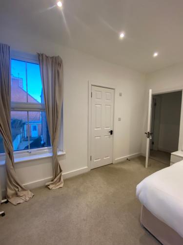 a bedroom with a bed and a window at Marble House in Edgware