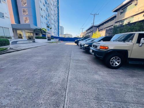 a street with cars parked in a parking lot at Tulip Garden condo in Biñan