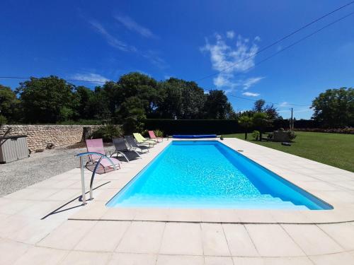 une piscine avec des chaises dans une cour dans l'établissement Villa de charme LA ROCHE AUX LIONS, à Archigny