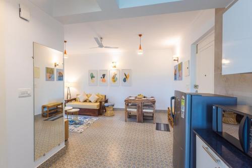 una sala de estar con un sofá y una mesa en Tranquil 1BHK suite Pool Field Calangute Da Alohas, en Calangute