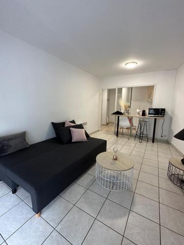 un salon avec un canapé noir et une table dans l'établissement Lourdes, à Nevers