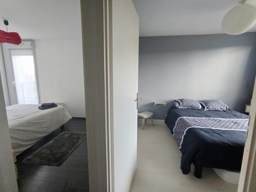 - une chambre avec deux lits et une chambre avec une fenêtre dans l'établissement Duplex proche Disney avec écran cinéma, à Chessy