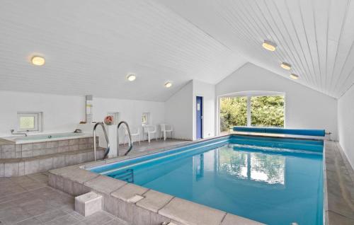 ein Swimmingpool in einem Haus mit einer Badewanne und einem Swimmingpool in der Unterkunft 2 Bedroom Lovely Home In Blåvand in Blåvand