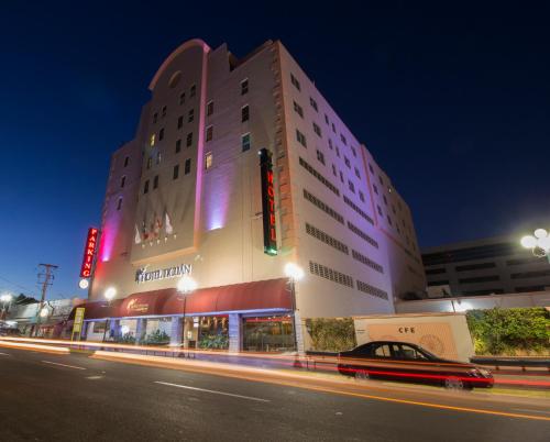 a building with a car on a street at night at Hotel Ticuán in Tijuana