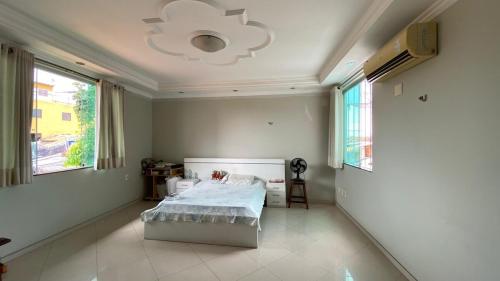 a bedroom with a bed and a chandelier at Cop 30 home with garden and lake in Belém